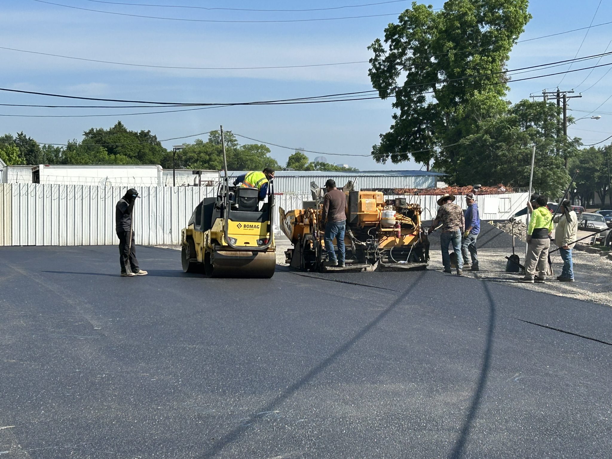 Construction crew paving road with asphalt roller