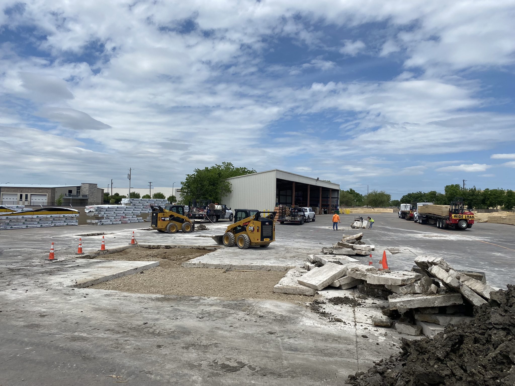 Construction site with skid steers and broken concrete